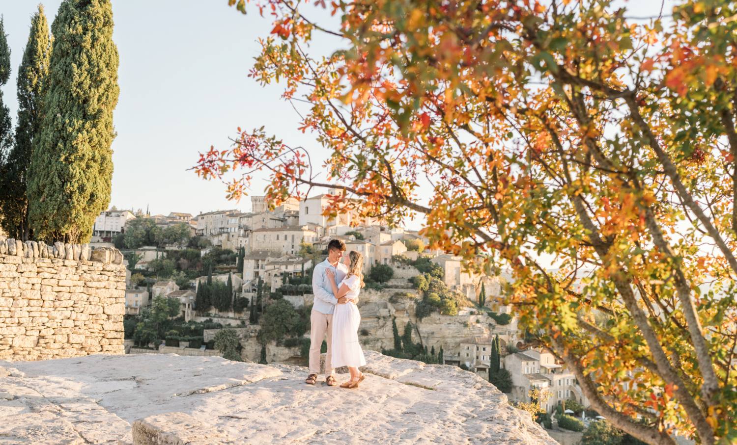 engaged couple embrace in autumn in gordes, provence france