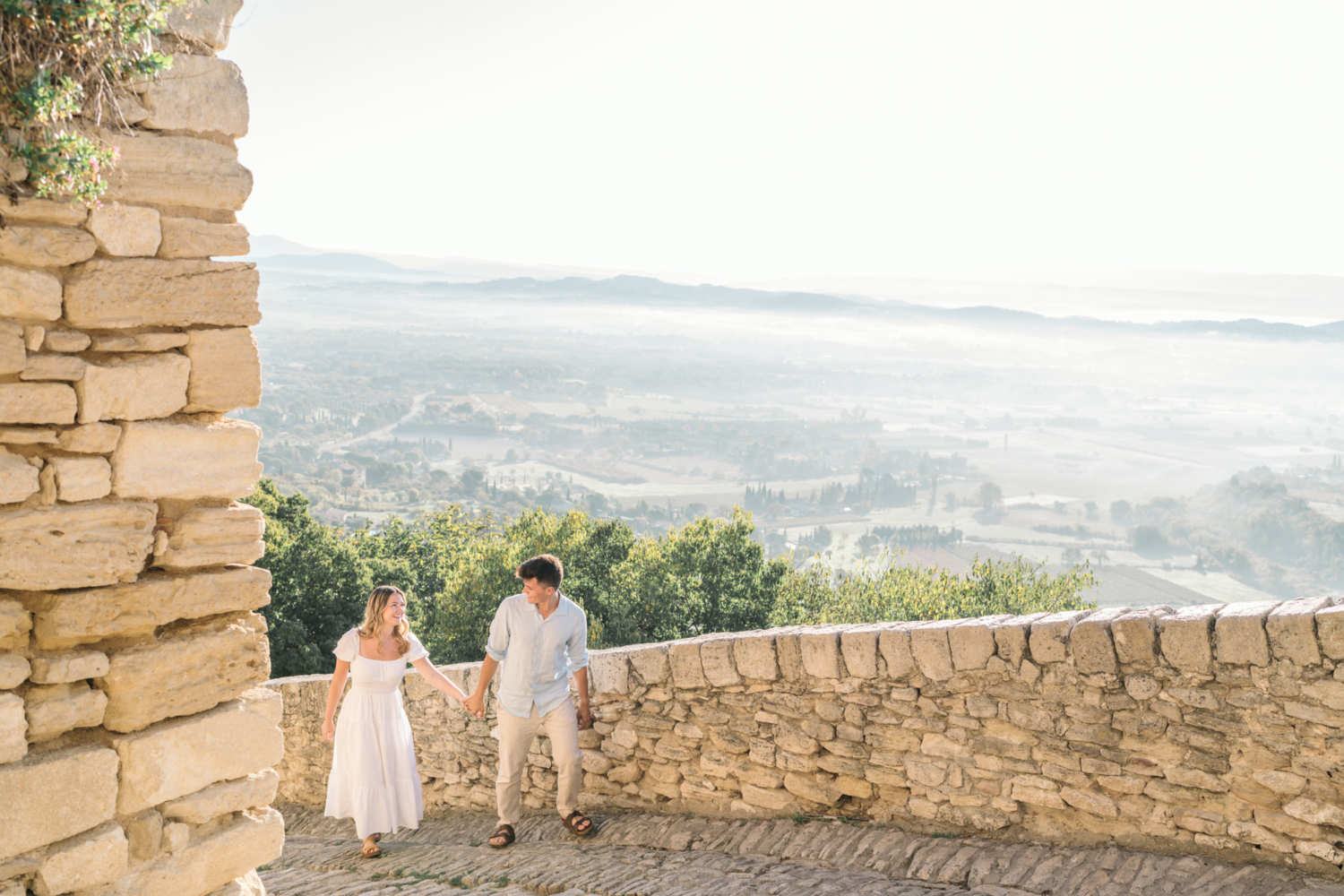 engaged couple walk around the streets of gordes, provence france