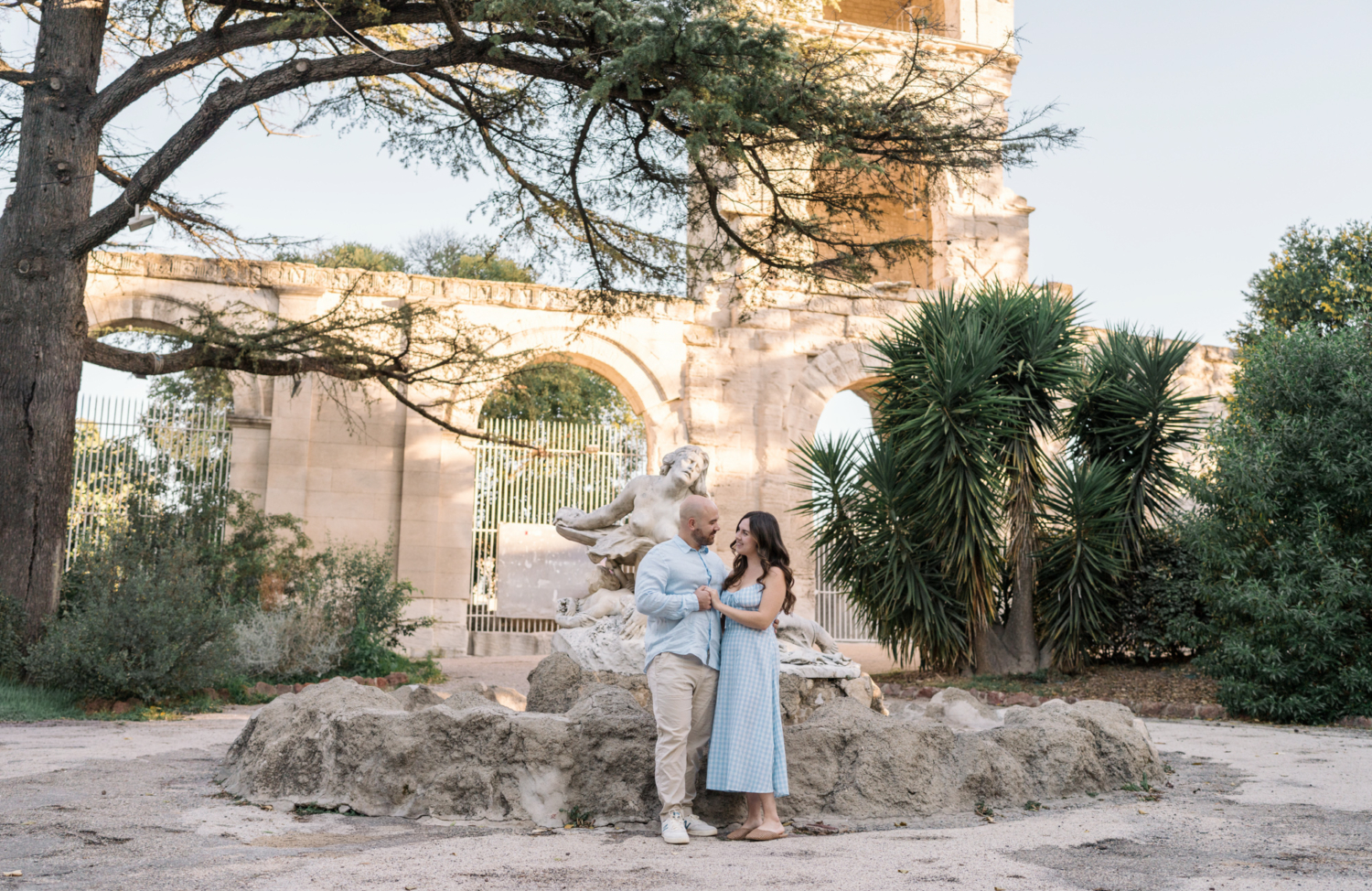 engaged couple holding hands in front of roman theater in arles france