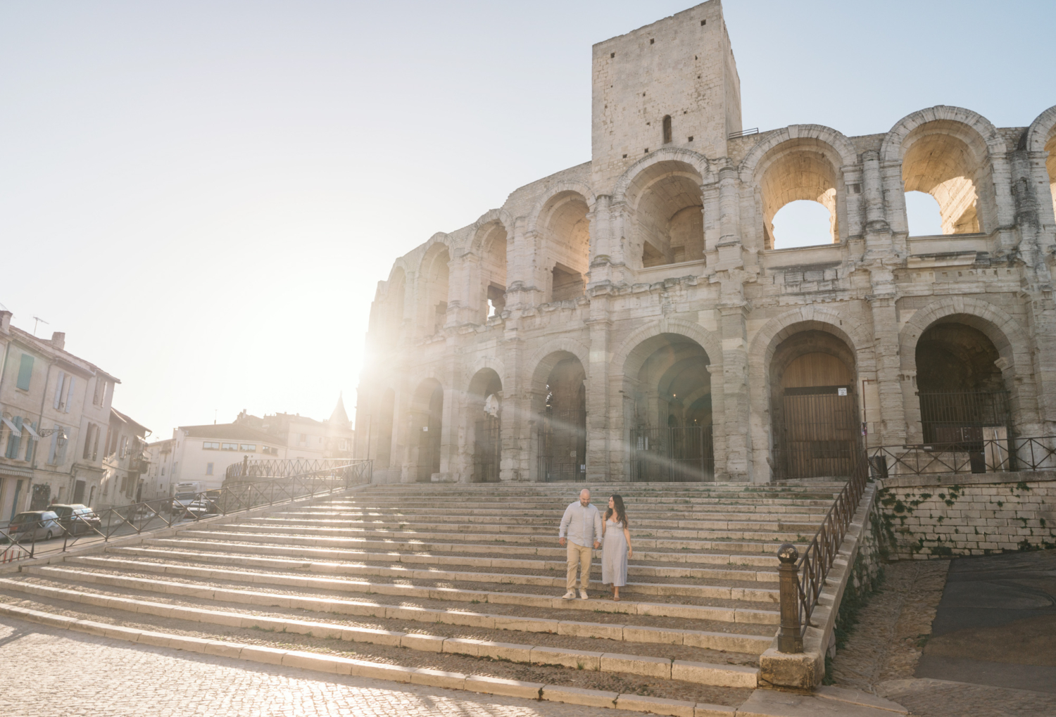 engaged couple walking down steps of roman colosseum in arles france