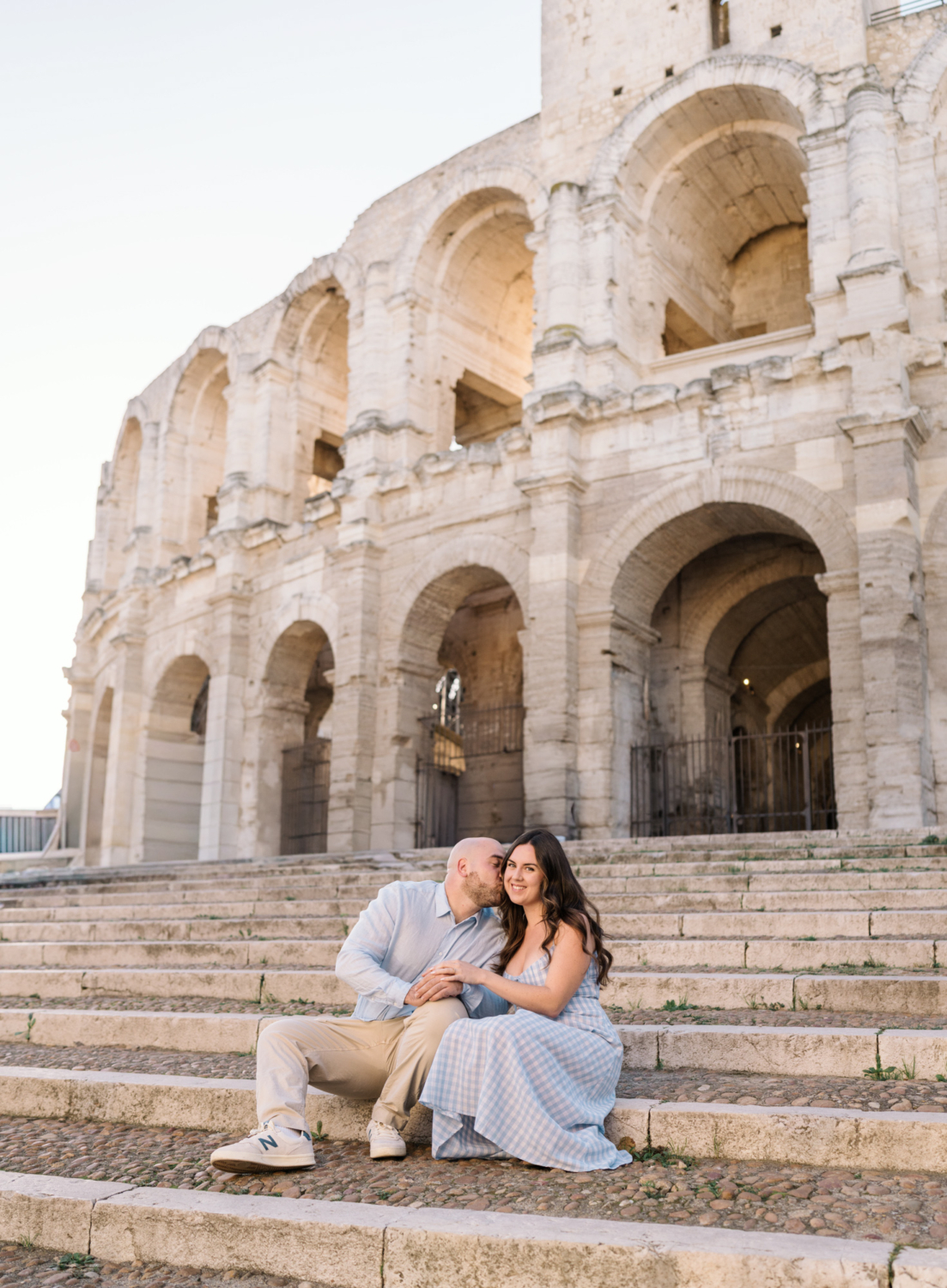 engaged couple kiss on steps of colosseum in arles france