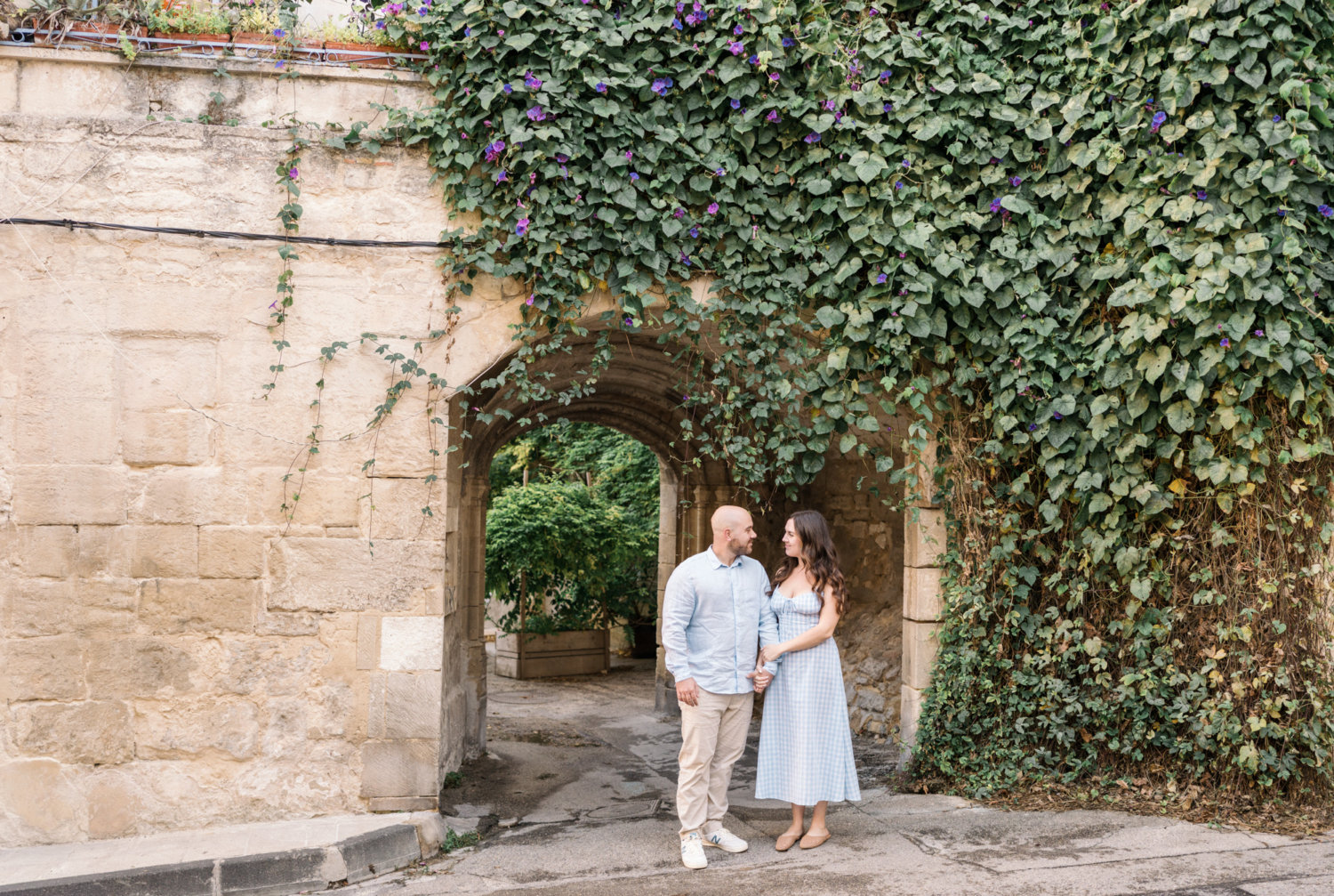 engaged couple pose under arch in arles france