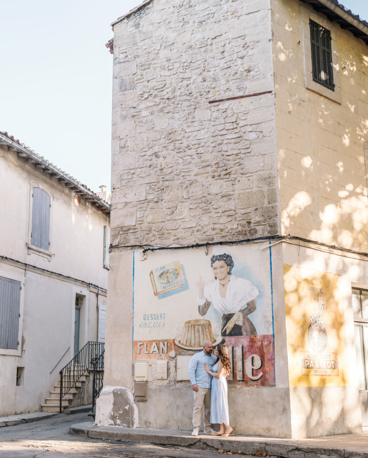 cute couple pose in front of antique advertisement in arles france