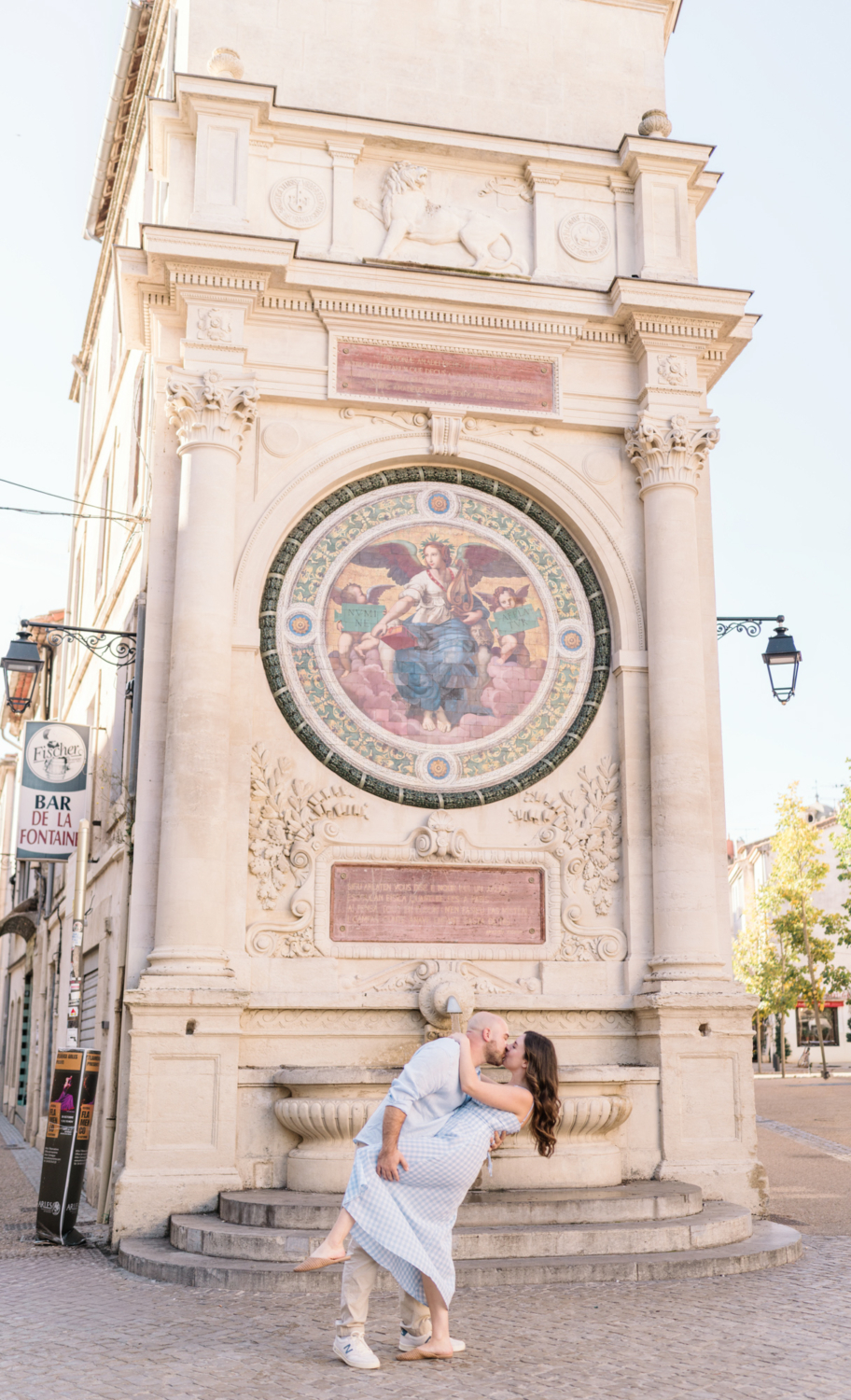 man dips woman in front of fountain in arles france