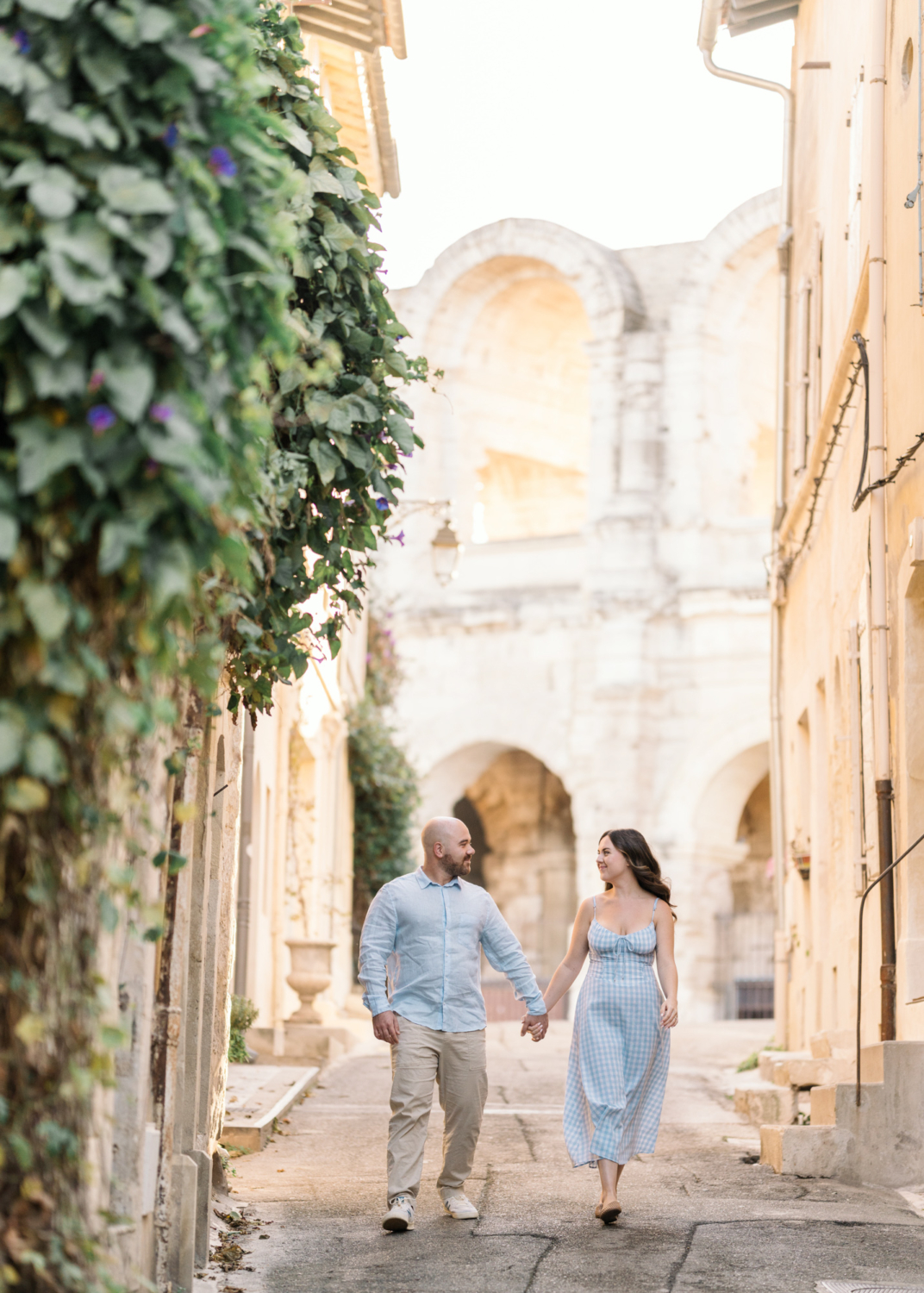 engaged couple walk hand in hand in arles france