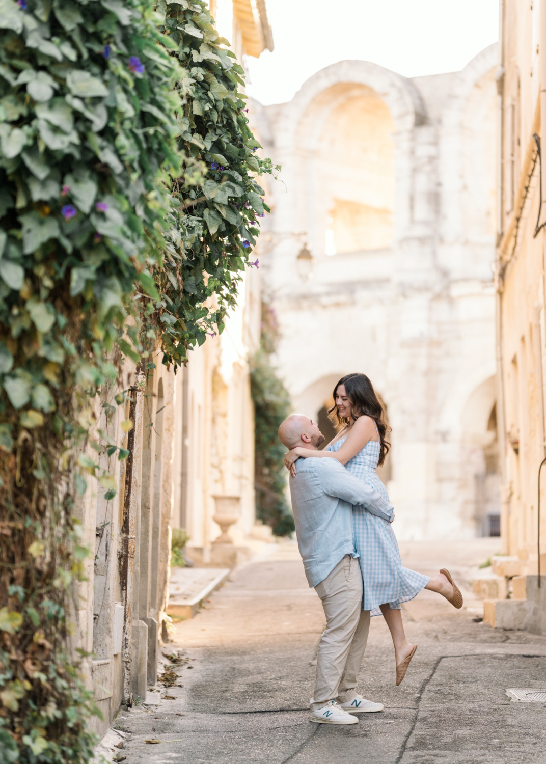 man lifts woman near roman amphitheater in arles france
