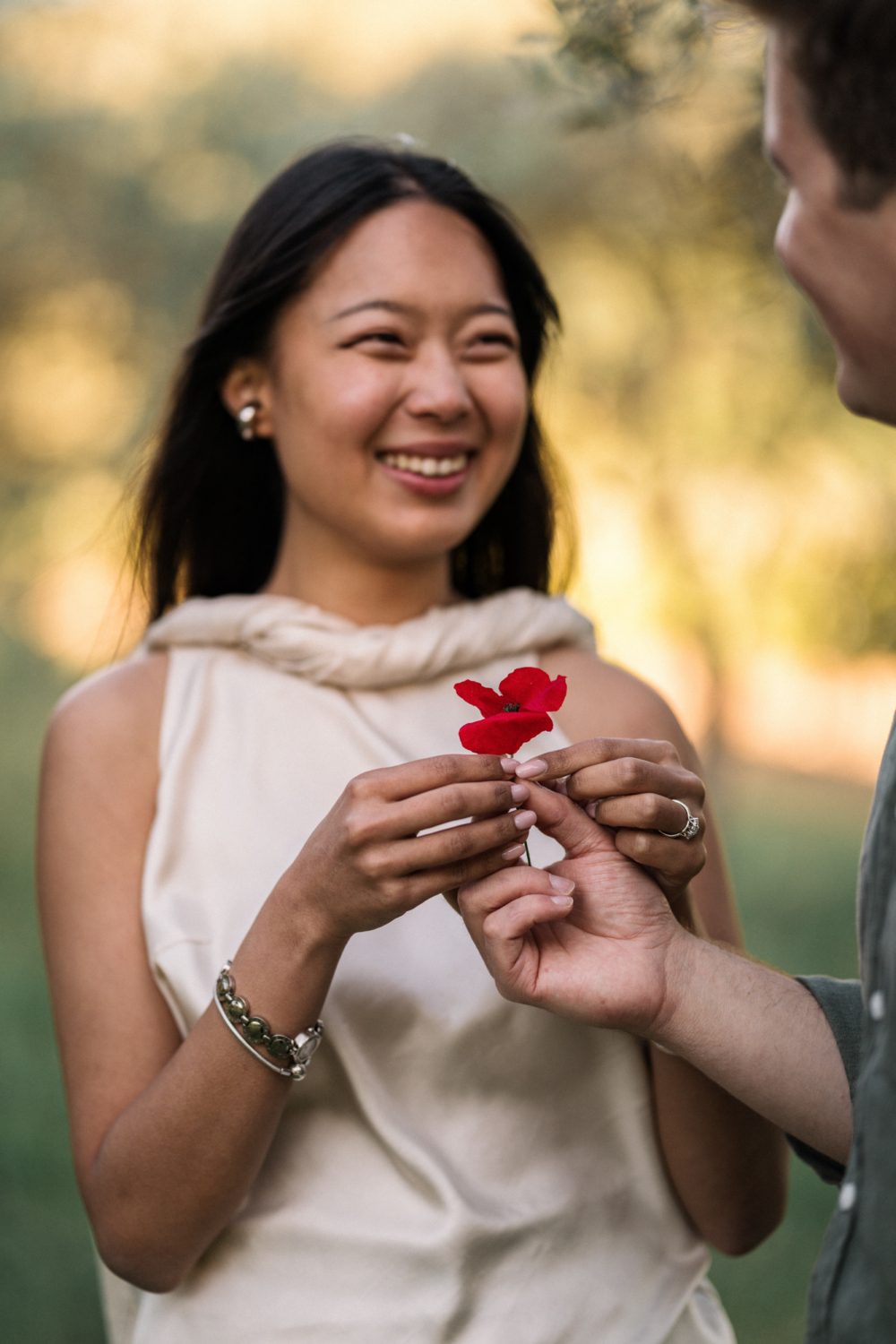 man presents red poppy to woman