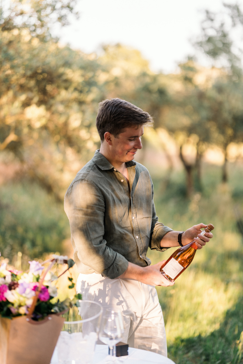 man gets ready to open a bottle of wine in provence
