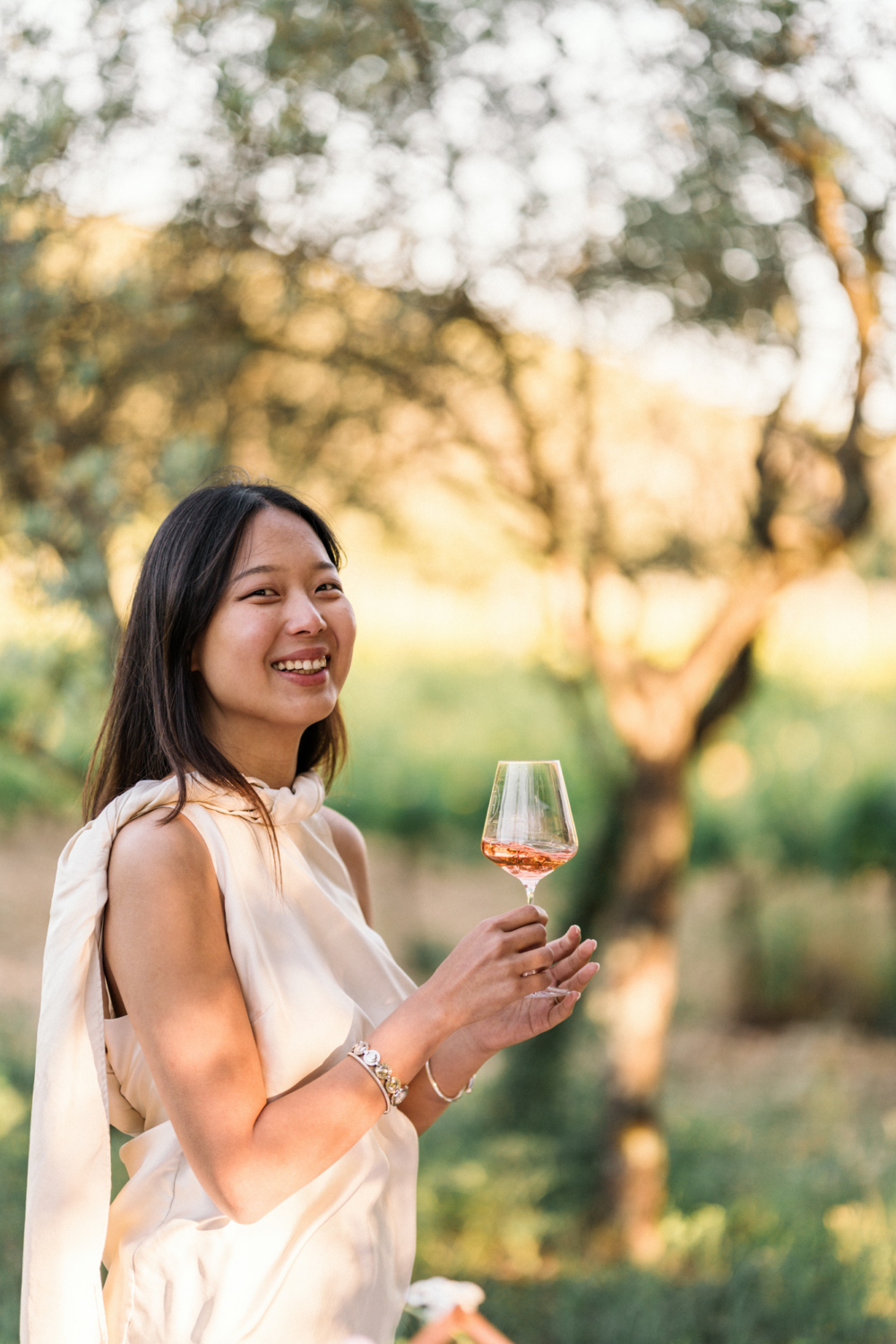 newly engaged woman smiles while holding a wine glass
