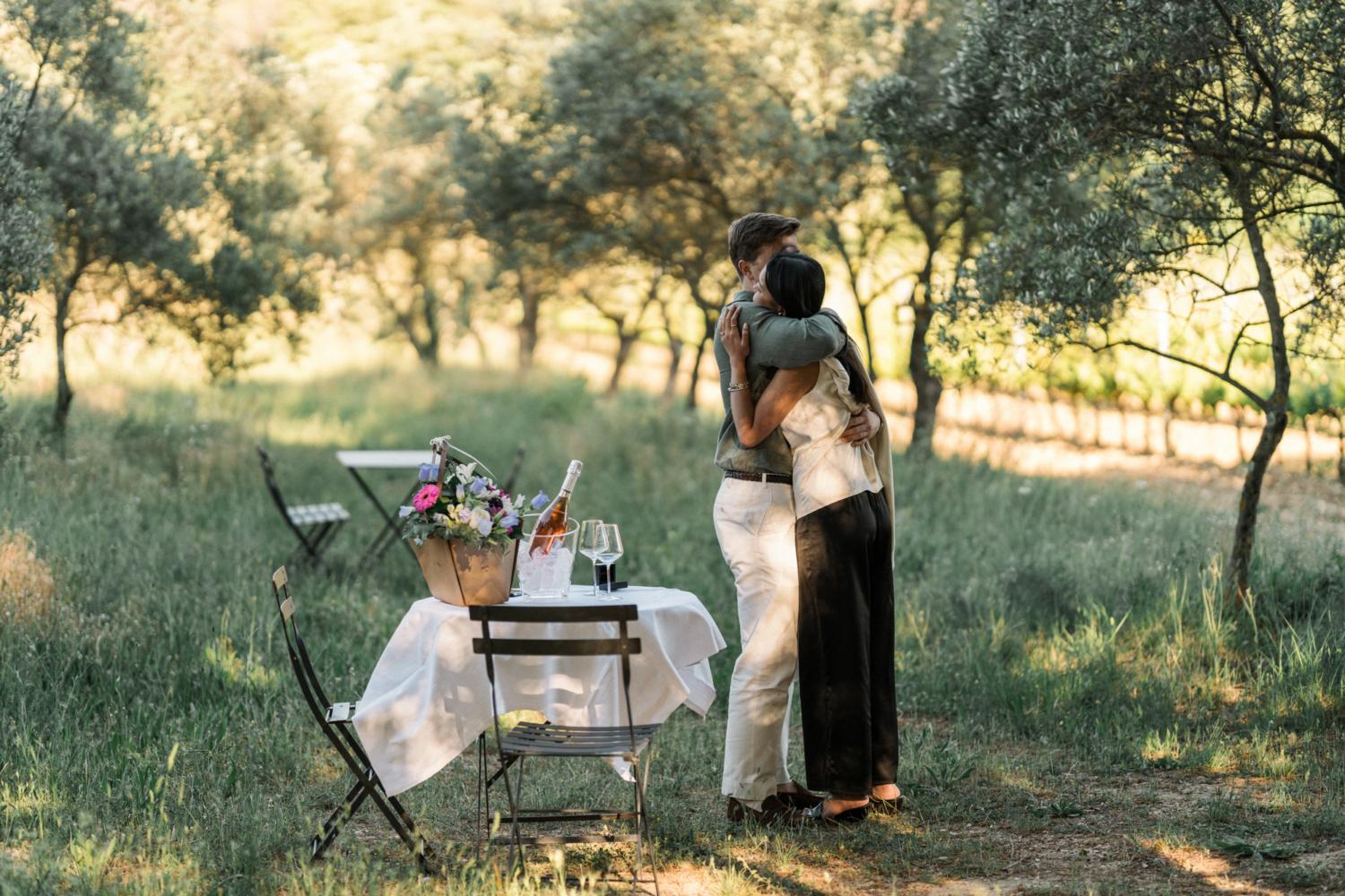 couple embrace after surprise proposal in vineyard