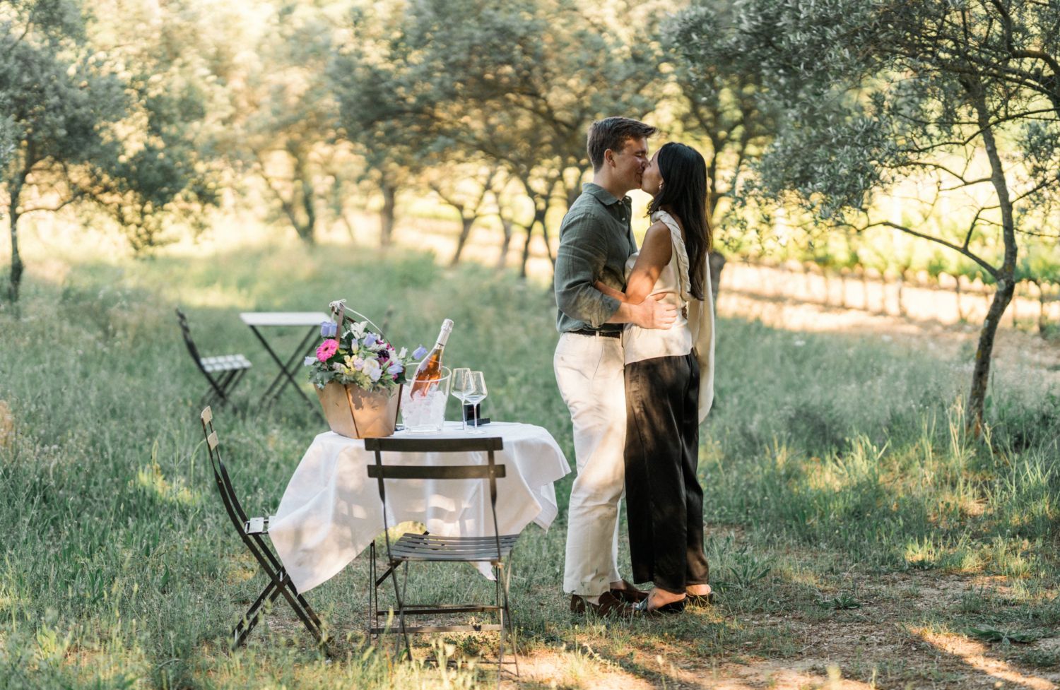 couple kiss after man proposes in vineyard