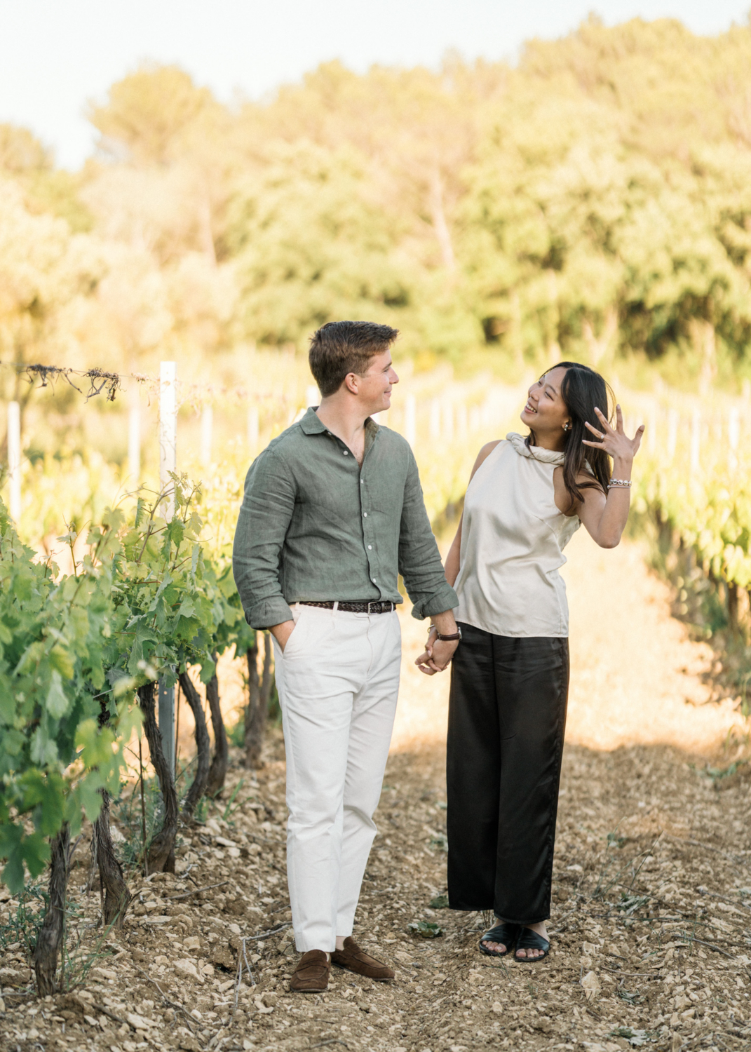 woman shows off her new engagement ring in a vineyard