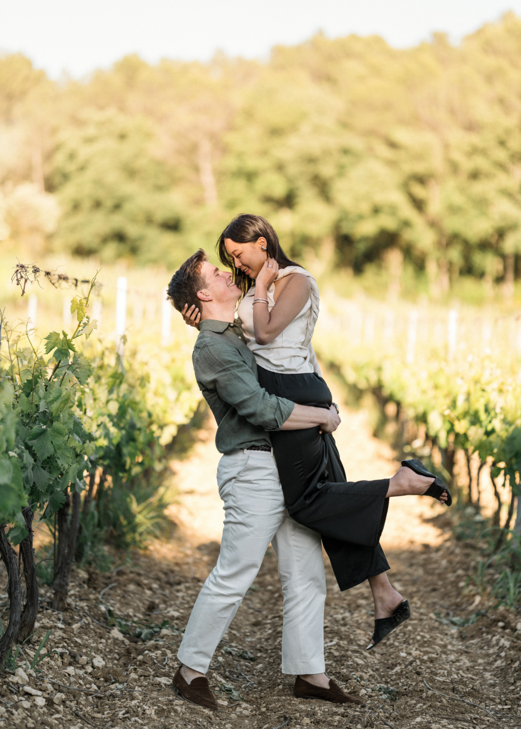 man lifts woman in vineyard in provence france