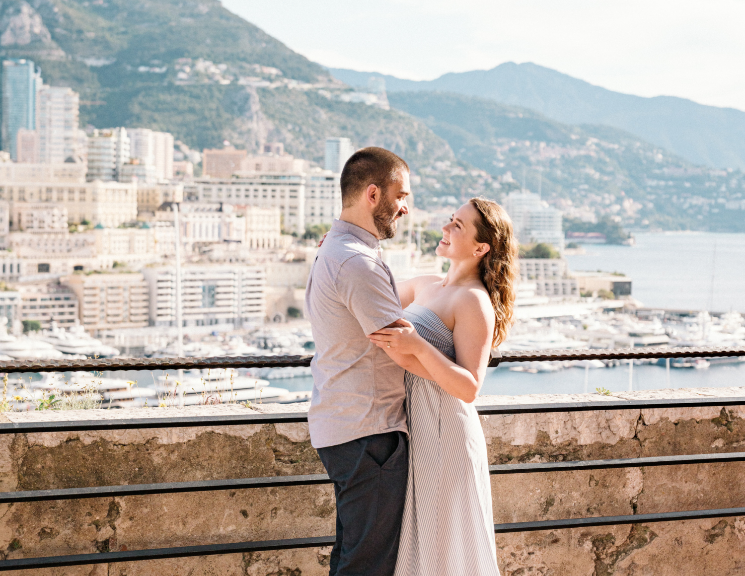 couple smiles at each other in monaco harbor