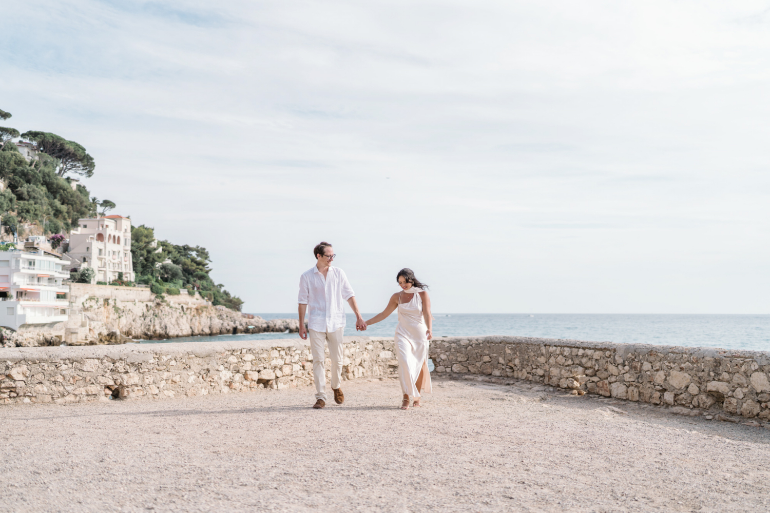 newly engaged couple walk hand in hand on coco beach in nice france