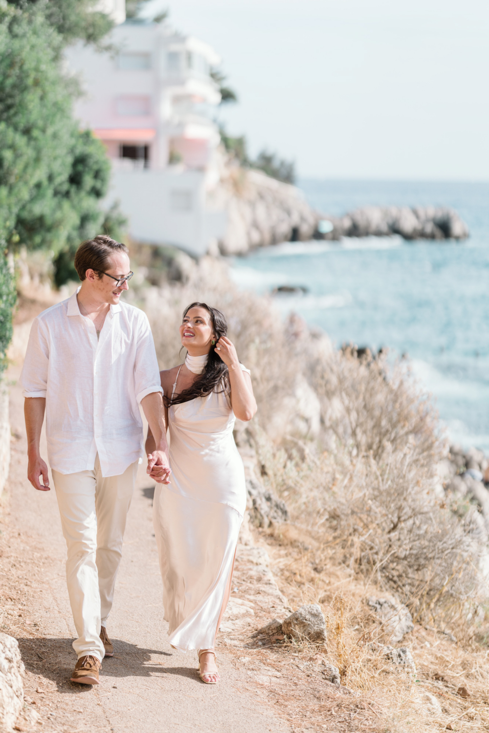 newly engaged couple walking hand in hand along the mediterranean in nice