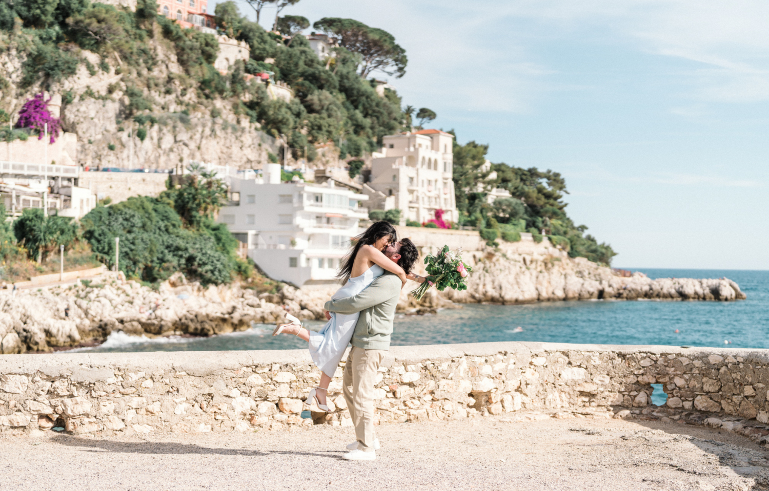 man lifts woman with view of the sea in nice, france