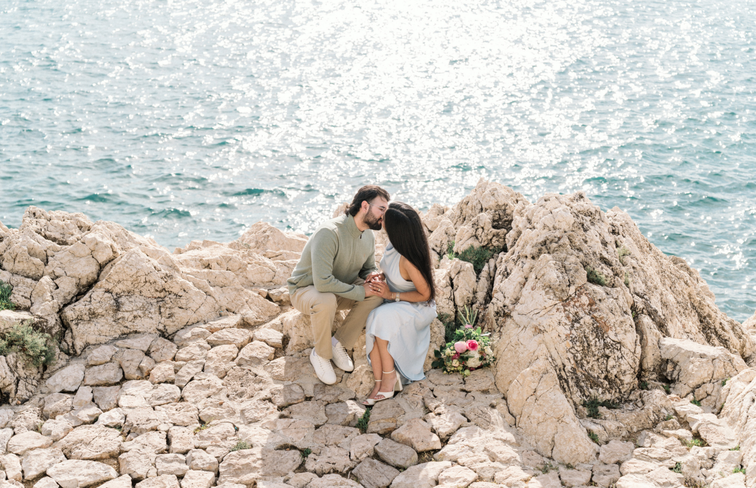 newly engaged couple kiss on rocks in nice, france