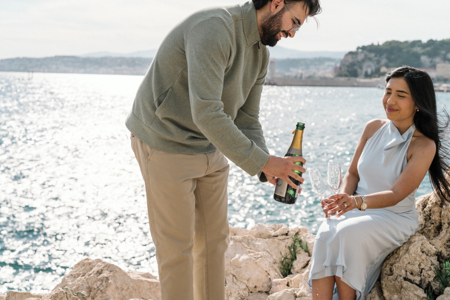 man pours champagne after engagement in nice, france