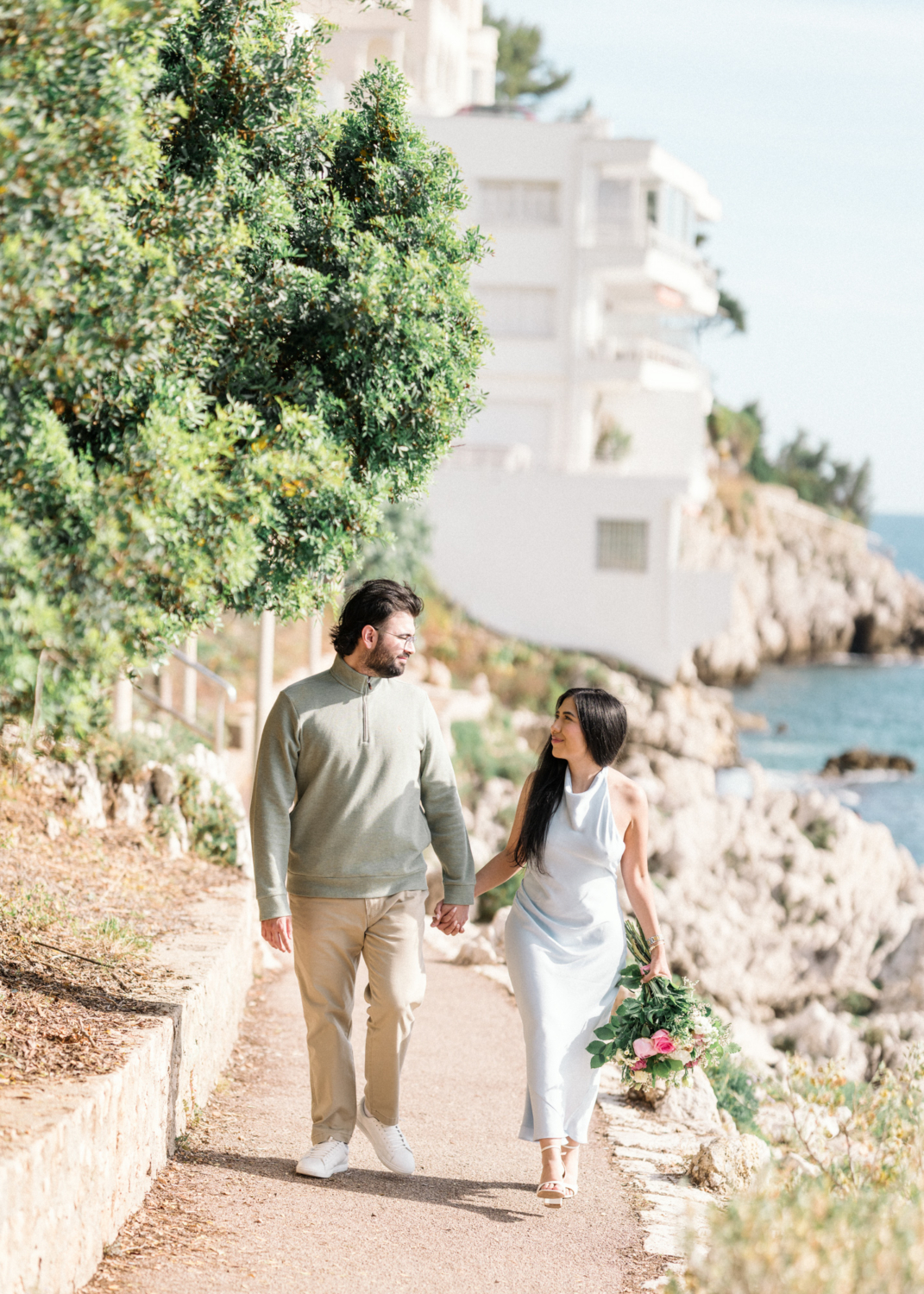 newly engaged couple walk next to sea in nice, france