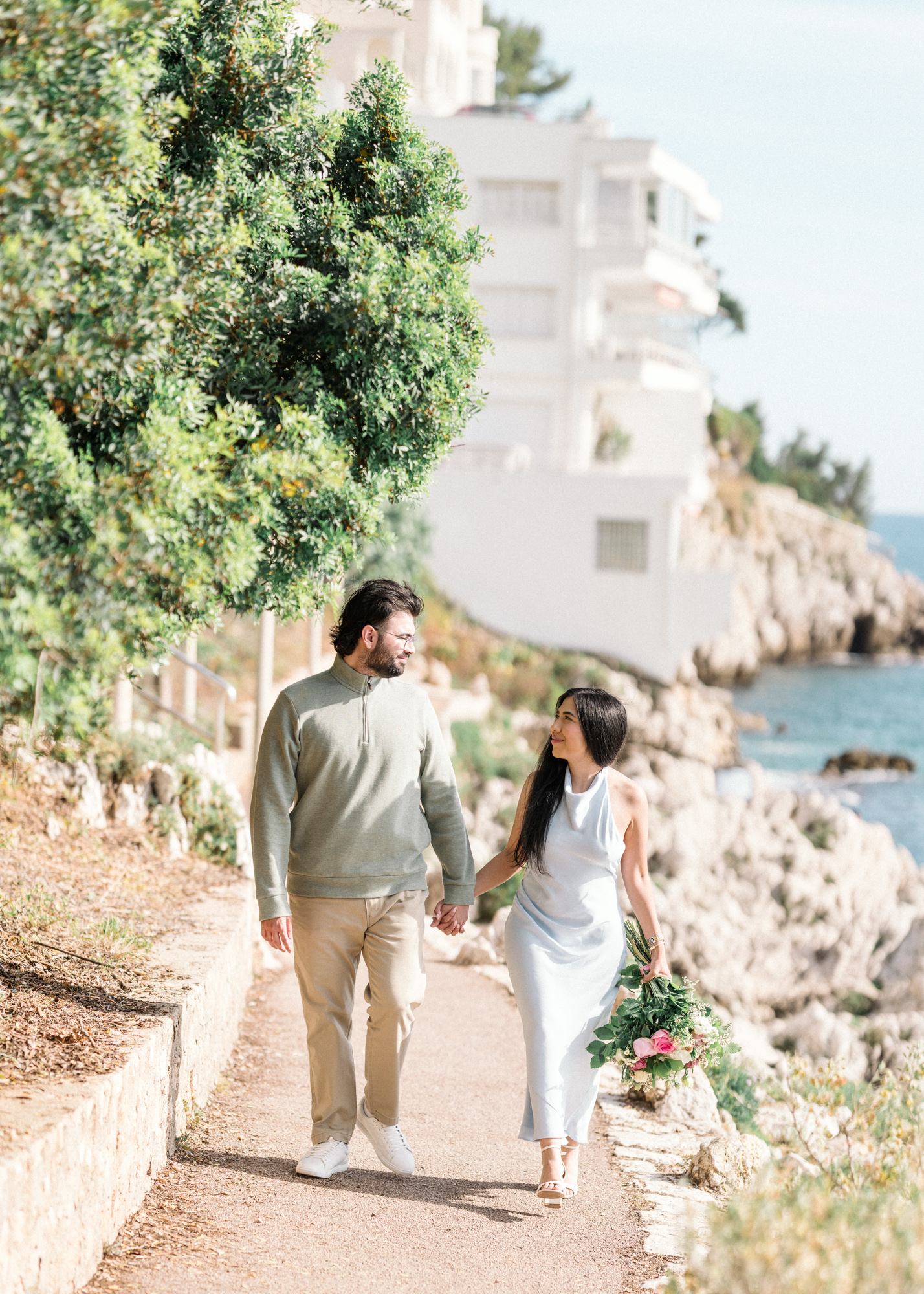 newly engaged couple walk next to sea in nice, france