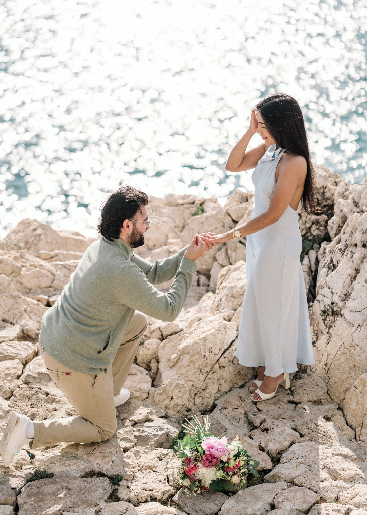 man puts engagement ring on woman's finger in nice, france