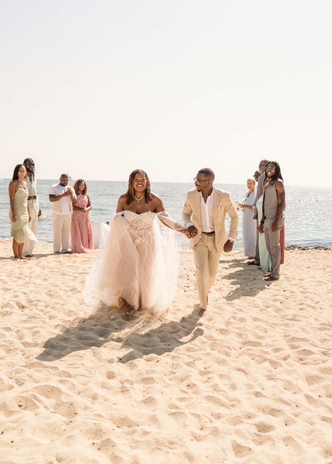 bride and groom run on the beach in saint tropez